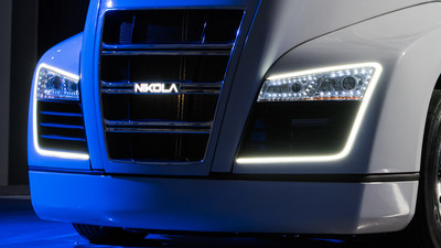 Front of the Nikola One promotional truck with illuminated headlamps and Nikola badge.